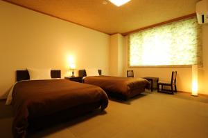 白马村橡树林酒店的酒店客房设有两张床和窗户。