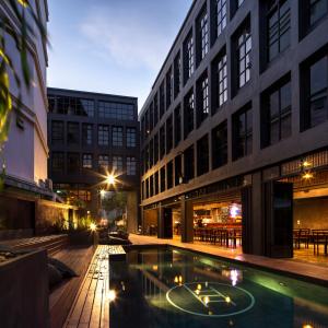 曼谷BED STATION Hostel Khaosan的庭院中间一座带游泳池的建筑