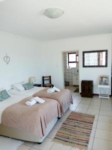 吕德里茨Kairos Cottage B&B的一间带两张床的卧室和地毯