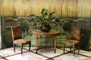 圣保罗圣拉斐尔酒店 的一间设有桌子和两把椅子的房间和盆栽植物