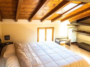 明乔河畔的瓦雷奇奥范斯托苏博尔盖托酒店的一间带一张大床的卧室,位于一个拥有木制天花板的房间