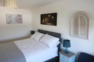莱姆里吉斯4a Dolphin Close的卧室配有白色的床和窗户。