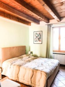 明乔河畔的瓦雷奇奥范斯托苏博尔盖托酒店的一间卧室设有一张带木制天花板的大床。