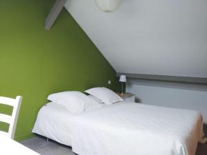 塔布Etage privatif的一间卧室配有一张白色的床和绿色的墙壁