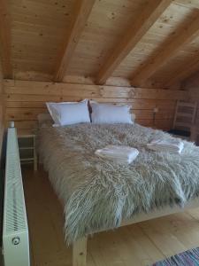 SăcelTulean Cabin的小屋内的一张带两个枕头的床