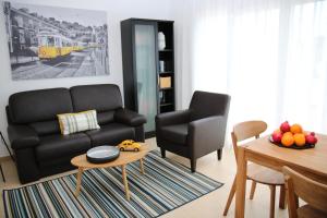 阿尔布费拉Pine Tree Apartments - Praia da Coelha - Albufeira的客厅配有黑色沙发和桌子