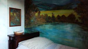 博尔戈马内罗Il Nido del Pettirosso的卧室墙上有绘画作品
