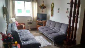瓜鲁雅Cobertura Enseada Guarujá的客厅配有两张沙发和一台电视机