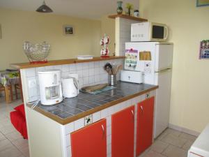 滨海苏拉克Logement Soulac sur mer的厨房配有红色和白色的家电