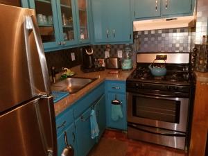 纽约Fully Furnished Entire Floor Apartment in Historic Harlem的厨房配有蓝色橱柜和不锈钢冰箱