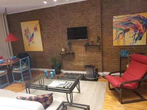 纽约Fully Furnished Entire Floor Apartment in Historic Harlem的客厅设有砖墙和电视