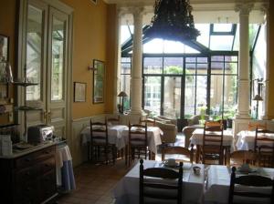 布鲁日特尔杜恩酒店的餐厅设有桌椅和大窗户。