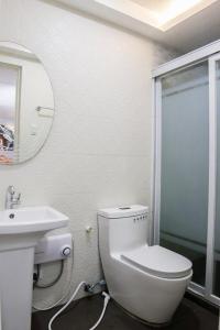 KoronadalMezza Hotel的白色的浴室设有卫生间和水槽。