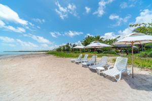 圣米格尔-杜斯米拉格里斯里亚舒海景酒店的海滩上的一排椅子和遮阳伞