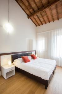 埃尔萨谷口村圣洛伦索公寓式酒店的一间卧室配有一张大床和两个红色枕头