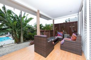 拉罗汤加Kia Orana Villas and Spa的一个带两把椅子的庭院和一个游泳池