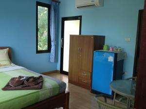 沙美岛Baan Mulan的一间卧室配有一张床、一张桌子和一面蓝色的墙壁