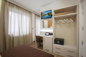 加利波利La Casa del Turista的一间卧室配有一张床、一张书桌和一台电视。