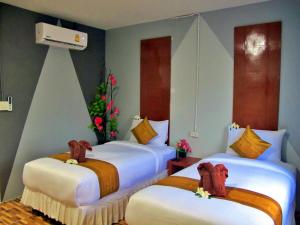 丽贝岛利普岛朝雷度假度假酒店的配有圣诞树的酒店客房的两张床