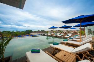 勒吉安New Garden View Resort - CHSE Certified的一个带躺椅和遮阳伞的游泳池