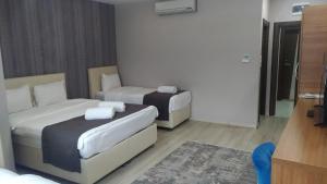 OsmancıkGrand Dost Hotel的酒店客房,设有两张床和一张沙发