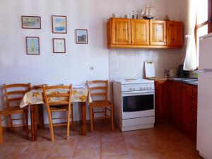 哈尔基岛Villa Yorgos的厨房配有桌子和白色炉灶烤箱。