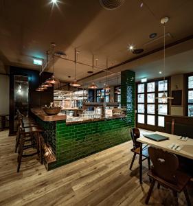 慕尼黑Marias Platzl的餐厅设有绿色酒吧,配有桌椅