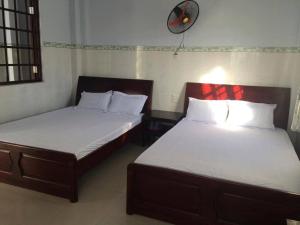 潘切Minh Duc Guesthouse的两张睡床彼此相邻,位于一个房间里