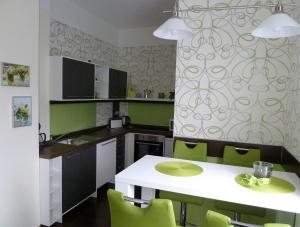 GerbrunnSchedler 2的厨房配有白色的桌子和绿色的椅子
