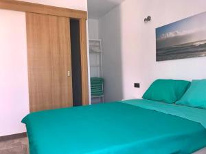 查德尔帕罗奥Sunny Studio Lanzarote的一间卧室设有蓝色的床和木门