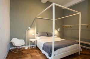 曼托瓦Casa Iolanda的卧室配有白色的天蓬床和椅子