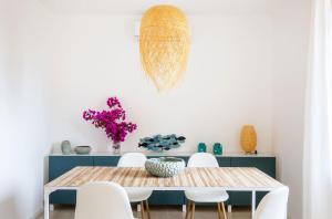 陶尔米纳La Matrangela Charme Apartments的一间带桌子和白色椅子的用餐室