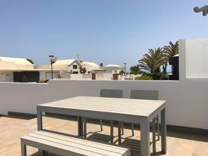 查德尔帕罗奥Sunny Studio Lanzarote的屋顶上的桌子和长凳