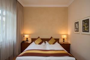 巴登赛克尔巴登酒店的一间卧室配有一张带2个床头柜和2盏灯的床。