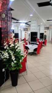 奥兰MARAVAL的用餐室设有红色的椅子和桌子,并鲜花盛开