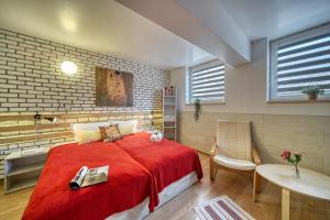 旧扎戈拉Fox Rooms Aparthotel的一间卧室配有红色的床和一张桌子及椅子