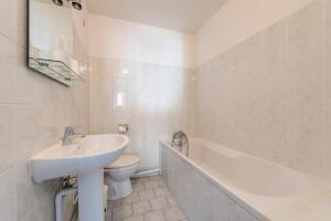 马赛杜金莎酒店的浴室配有盥洗盆、卫生间和浴缸。