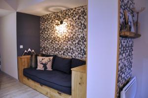 拉姆吉Appt Le Caribou/La Mongie的客厅配有蓝色沙发,靠墙