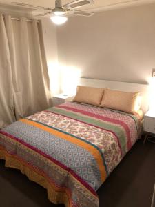 珀斯5A Glenelg Street的一间卧室配有一张带两盏灯和两张桌子的床。
