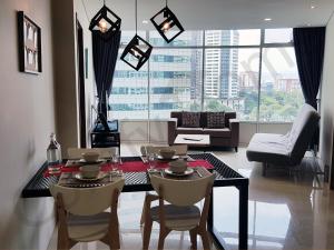 吉隆坡靠近KLCC/吉隆坡市中心5星级豪华公寓的客厅配有桌椅和沙发