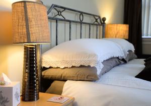 布里德灵顿The Villa Bridlington的一张带两个枕头的床和一张桌子上的台灯