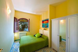 康加德马里尼Casa Marea的一间卧室设有一张绿色的床和一个窗户。