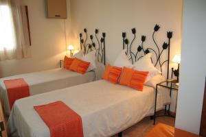 拉法莱斯拉尔奎利亚酒店的两张带橙色和白色枕头的床