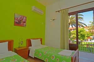 斯达林Othonas Apartments的绿色的客房设有两张床和窗户。