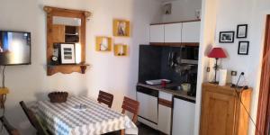 拉普德兹La Dauphinoise Alpe d'Huez的一个带桌子的小厨房、一个带桌子的小厨房和一间厨房