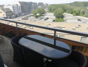 布列登Duinenzicht的阳台配有桌子,享有停车场的景致。