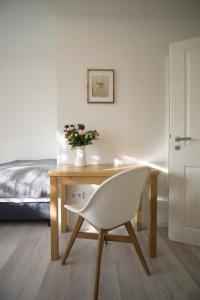 Weisenheim am SandFerienwohnung Charlotte的卧室内的一张带白色椅子的桌子