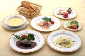 日光日光金谷酒店 的餐桌,盘子和一篮面包