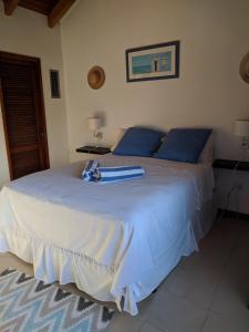 辛普森湾Simpson Bay Yatch Club 2 Bedrooms的一张带蓝色枕头的白色床和冲浪板