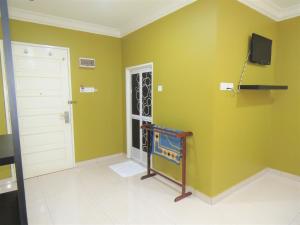 瓜埠Gm Motel的一间设有绿色墙壁、门和电视的房间